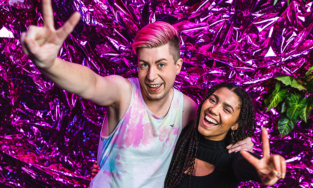 Partygaeste machen Handzeichen vor der pinkfarbenen FotowandBlick in das Foyer der Pepsi Boston Bar im SchwuZ Queer Club Berlin